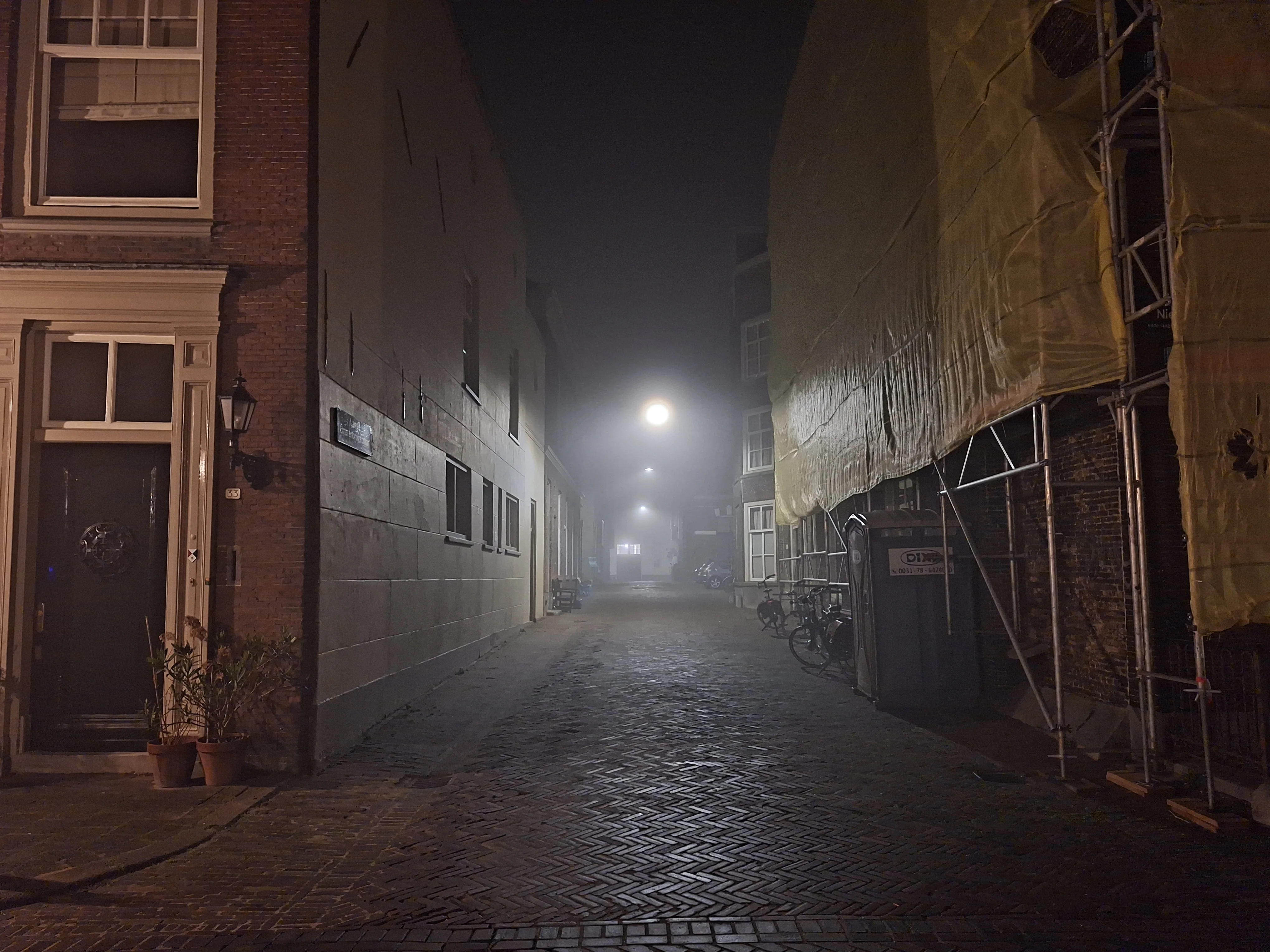 Narrow side street receding into fog